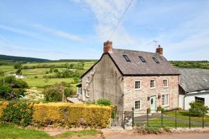 una antigua casa de piedra en el campo en Bedlwyncoch Farmhouse, en Brecon