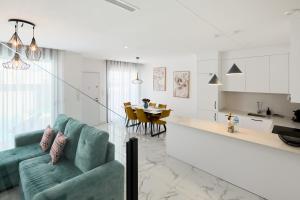 a living room with a green couch and a kitchen at Rojales Golf House - by Welcomely in Rojales