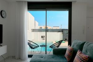 a living room with a couch and a view of a pool at Rojales Golf House - by Welcomely in Rojales