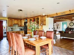 Una cocina y un comedor con mesa y sillas de madera. en Bedlwyncoch Farmhouse, en Brecon