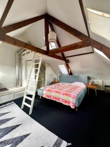 a attic bedroom with a bed and a ladder at Casa di Kola in Zutphen