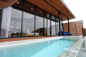 einen Pool in einem Gebäude mit Glaswänden in der Unterkunft Yume17 - Sea View Villas in Chaloklum + 33 Fotos