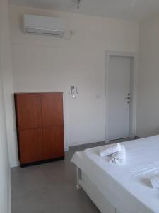 a white room with a bed and a wooden cabinet at מנוחה בגולן in Haspin