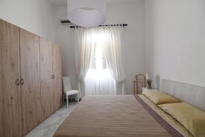 ポリニャーノ・ア・マーレにあるAffittacamere A Pochi Passiのベッドルーム(大型ベッド1台、窓付)