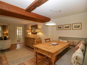 ein Wohnzimmer mit Tisch und Couch in der Unterkunft The Cottage in Cheltenham