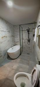 a bathroom with a toilet and a bath tub at Le Feto in Dakar +29 photos