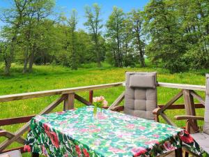 a table and a chair with a floral table cloth at 4 person holiday home in Götene in Götene