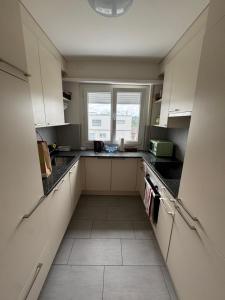 a small kitchen with white cabinets and a window at Appartement cosy & meublé Fribourg in Fribourg