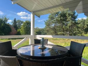 a table and chairs on a patio with a view at Domki w Lesie in Silnowo +34 photos