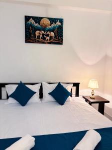 Un dormitorio con una cama grande con almohadas azules. en Muthumala Villa, en Tangalle