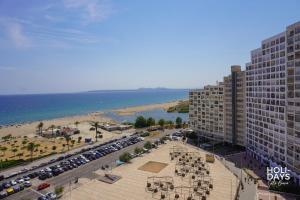 エンプリアブラバにあるHolidays Sol y Mar, beachfrontの建物と駐車場のあるビーチの景色