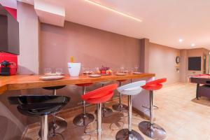 a kitchen with a bar with red and black stools at Sunset Casa Rosi in Alcudia