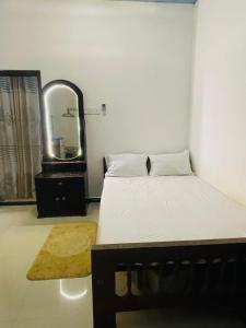 une petite chambre avec un lit et un miroir dans l'établissement Mount Lavender Weligama, à Weligama