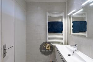 a white bathroom with a sink and a mirror at Lesdiguieres 3 Bedrooms Parking in Grenoble +13 photos