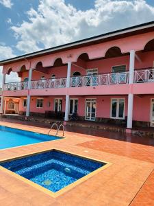 a large building with a swimming pool in front of it at Villa Kidege in Accra