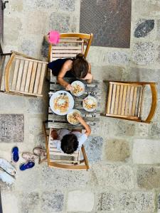 twee mensen aan een tafel met borden eten bij Casa Betta - A 700 Year Old Tuscan Gem in Chiusdino