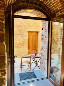 een glazen deur naar een patio met een tafel bij Casa Betta - A 700 Year Old Tuscan Gem in Chiusdino