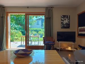 ein Wohnzimmer mit einer großen Glasschiebetür in der Unterkunft La Belmontine Maison avec jardin Uriage-les-Bains in Vaulnaveys-le-Haut