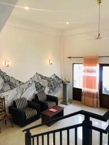 a living room with two chairs and a couch at Heaven Hill Guesthouse in Weligama