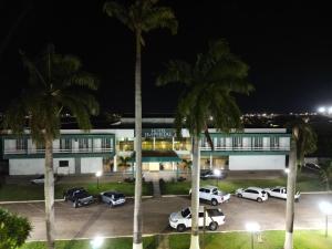 a parking lot with cars parked in front of a building at Hotel Imperial Mirassol d'Oeste in Mirassol D´Oeste
