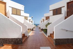 eine Gasse zwischen zwei Gebäuden mit weißen Wänden in der Unterkunft Casa Relax Marine in Costa Del Silencio