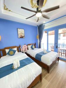 two beds in a room with a ceiling fan at Sadakham Royal View Hotel 1 in Luang Prabang +113 photos