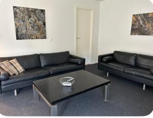 a living room with two black couches and a coffee table at Ammitsbøl Apartment B in Vejle