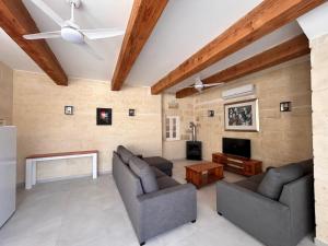 a living room with two couches and a tv at Ta' Marija in Sannat