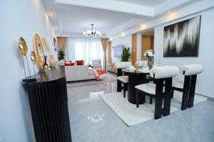 a living room with a table and chairs and a living room at Pearl Luxury Two Bedroom Apartment at Orchid Residency by Kaisa, Westlands, Nairobi in Nairobi