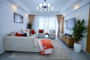 a living room with a couch and a television at Pearl Luxury Two Bedroom Apartment at Orchid Residency by Kaisa, Westlands, Nairobi in Nairobi