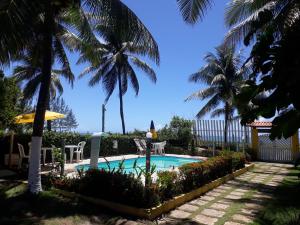 Village Pousada Canedo في غايبيم: مسبح فيه نخيل في ساحة