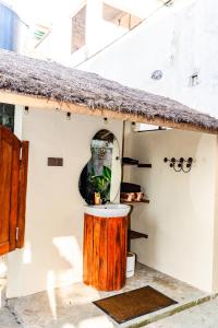a small house with a round window and a wooden stump at Balangan Bali Bungalow in Uluwatu