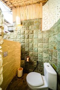 a bathroom with a white toilet in a room at Balangan Bali Bungalow in Uluwatu +18 photos