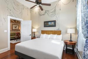 a bedroom with a white bed and a ceiling fan at 4BR Luxury Uptown Retreat w Private Heated Pool in New Orleans