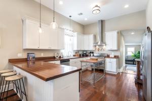 a kitchen with white cabinets and a wooden counter top at 4BR Luxury Uptown Retreat w Private Heated Pool in New Orleans