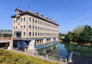 an old building with a bridge over a river at Proche Paris et Disneyland T2 calme avec Terrasse in Noisiel