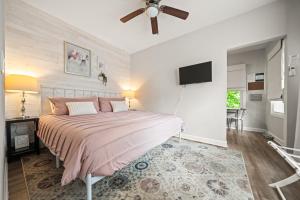 Un dormitorio con una cama y un televisor de pantalla plana. en Spring Bungalow - A cozy getaway in downtown Hot Springs!, en Hot Springs