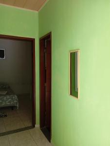 フェイラ・デ・サンタナにあるhospedagem próxima ao centro apto luxoの緑の壁と鏡が備わる部屋