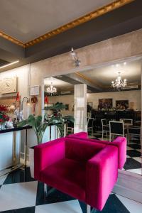 a pink couch in a room with a restaurant at Hotel Aria center in Tirana