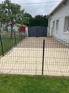 a fence in a yard next to a house at Maison à la campagne in Combon +1 photo