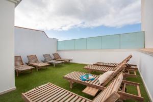 a patio with chairs and tables on a building at Corralejo Ian’s Dreams in Corralejo