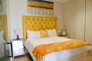 1 dormitorio con 1 cama grande y cabecero amarillo en Luxury Escape at Ellipse 1-Bed, Kitchen, Wi-Fi & Free Parking, en Midrand 19 fotos más