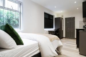 Spon EndにあるModern Studio near Cov Uni, City Centre, BHX & NECのベッドと大きな窓のある白い寝室 +17枚の写真