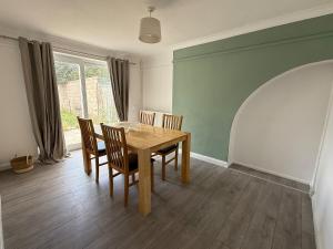 a dining room with a wooden table and chairs at Cosy 3 Bedroom Home, Parking & Bus in Oxford