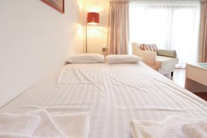 a white bed with two pillows on top of it at Cozy 1BR With Spa Near Ski Lift in Bansko
