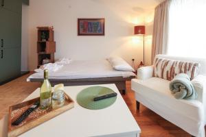 a living room with a white couch and a bed at Cozy 1BR With Spa Near Ski Lift in Bansko