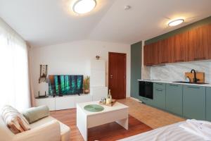 a kitchen with a couch and a table in a room at Cozy 1BR With Spa Near Ski Lift in Bansko