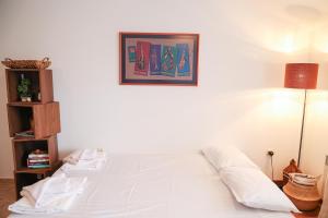 a bedroom with a white bed with a picture on the wall at Cozy 1BR With Spa Near Ski Lift in Bansko