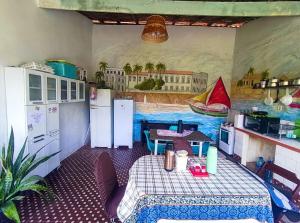a kitchen with a table and a painting on the wall at durmaaquislz in São Luís