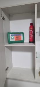 a bottle of detergent and a container on a shelf at Secret Studio Braila in Brăila